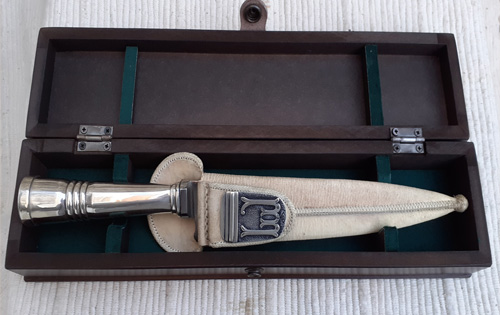 Cuchillo criollo labrado en plata con iniciales y vaina decuero crudo en caja de madera laqueada 